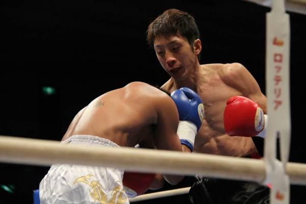 角谷 淳志選手が相手選手に右手パンチをし、相手選手が防御している写真